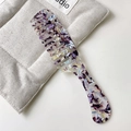 Wide-tooth acetate comb featuring elegant purple and black marble patterns on soft cushion - Floral Purple