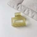 Close-up of a large yellow translucent square claw clip with hollow geometric design - Small Square / Small Square Green
