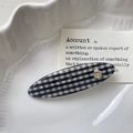 Nahaufnahme der schwarz-weißen Karo-Haarspange mit Herz-Strassstein auf Tablett - Schwarzes Gingham Oval-Clip