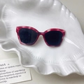 Rosafarbene Cat-Eye Sonnenbrille mit dunklen Gläsern auf einer weißen Muschelschale - 1#Rot