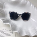 Detail einer Acetat-Sonnenbrille mit Schildpatt-Muster auf weißem Muscheltablett - 3# Texturiertes Schwarz