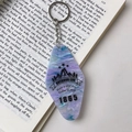 Macro detail of diamond acrylic keychain with blue marble pattern on an open book - Purple Marble