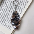 Close-up of marble pattern acrylic key tag with mountain print on a vintage book - Brown
