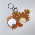 Detailansicht des orangefarbenen Glitzer-Acryl-Krabben-Schlüsselanhängers mit kleinem Spiegel - Krabbe