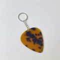 Detail of guitar pick keychain with dark amber tortoiseshell texture on white background - Leopard With Silver Buckle