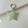 Macro detail of green glitter acrylic star keychain with a smiling face and metal ring - Glitter Green