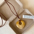 Vintage heart shaped yellow quartz stone pendant necklace with brown cord on natural background - Yellow Jade