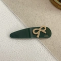 Detail of dark green acetate hair clip with a brown bow and gold France Handmade logo - Lake Green