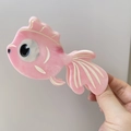 Detaillierte Nahaufnahme einer rosa fischförmigen Haarklammer aus glattem Acetat - Rosa