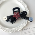 Dettaglio della pinza per capelli vintage rossa con bottoni, fiocco nero e stelle - Stella a cinque punte / Nero