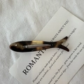Detailed close-up of a fish-shaped acetate hair clip with classic tortoiseshell pattern - Tortoiseshell