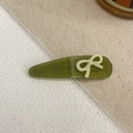 Olive green acetate teardrop hair clip with a cream white 3D bow accent and gold lettering - Green