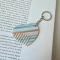 Dettaglio del portachiavi a pettine a cuore marmorizzato su un libro d'arte per DIY - Fibbia Argento - Blu a Righe