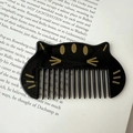 Portable cute black cat hair comb for kids, compact anti-static styling brush on a book - Black