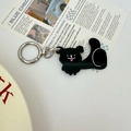 Detailed view of a black bear keychain with silver metal clasp on a magazine background - Black Dog