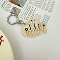Detailed close-up of fish-shaped acetate comb keychain with marble texture and silver ring - Beige Marble Fish