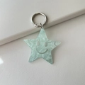 Mint green acrylic star keychain with marble texture and smiley face engraving - Glitter Blue