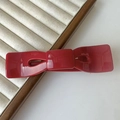 Dettaglio di un fermaglio per capelli a fiocco rosso in resina lucida su un vassoio gioielli - Medio Grande / Rosso Angola (78661)
