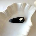 Nahaufnahme einer schwarzen Acetat-Haarspange mit Blume auf einer Schale - Schwarz