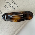 Gros plan sur la pince à cheveux ovale en acétate ambre avec motif écaille de tortue - Couleur Française Brillante (environ 11,5 cm)