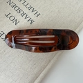Vue macro détaillée de la pince à cheveux ovale en écaille sur un fond de toile minimaliste - Écaille de Tortue Brillante (environ 11,5 cm)