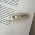 Creamy beige oval acetate hair clip with AMY BEAR logo and metal core - Off-white