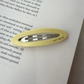 Pale yellow acetate oval hair clip with silver metal snap and AMY BEAR text - Yellow