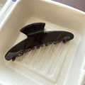 Close-up of chocolate brown hair claw with golden Barrette la France logo in a tray - Style 5 Large Hanger