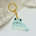 Close-up of mint green marble cat comb keychain with gold hardware on white lace - Approx: 5.4cm*3.7cm / Gold Chain - Blue