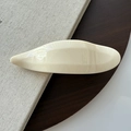 Minimalist cream-colored resin hair clip with glossy finish and streamlined curve design - Creamy White