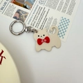 Chic cream cat keychain with red bow and silver ring accessory on a magazine - Beige Cat (dp)