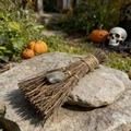 Detail of a handmade witch broom with natural raw stone on a rustic stone background - Labradorite / 10cm