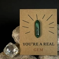 Gepolijst groen hexagonaal kristal op een geschenkkaart met You're a Real Gem - Malachiet