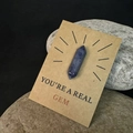 Detail van natuurlijk paars kristal op kraftkaart met de tekst You are a real gem - Blauwe Aventurijn