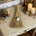 Vue détaillée d'un balai décoratif artisanal avec cristal blanc sur une table en bois rustique - Balai avec quartz rose