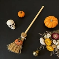 Mini Halloween witch broom with pumpkin pendant and wooden handle over a black background - Little Pumpkin Green