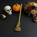 Miniature witch broom detail with yellow bat charm and natural straw texture for Halloween - Bat
