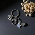 Dettaglio del ciondolo albero della vita e pietra di cristallo su un portachiavi d'argento - Albero della Vita E Quarzo Fumè