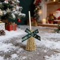 Close-up of decorative Christmas broom with Merry Christmas ribbon and wooden handle - Green