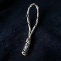 Detail view of a braided Viking keychain with a silver sun-patterned metal bead - Camo Coffee