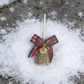 Close-up of decorative Christmas mini broom with red-green striped bow and small gold bell - Colorful Bell