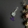 Detail of natural green crystal hair charm with purple wizard hat on dark background - Fluorite With Witch Hat