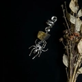 Macro shot of silver spider dreadlock jewelry featuring a raw citrine crystal stone - Tiger Eye With Spider