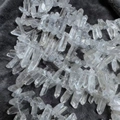 Natural clear quartz crystal point pendants on dark grey faux fur background - Transparent Crystal Cluster Strand