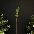 Detail of green crystal prism wrapped in copper wire on a dark background - Yellow & Green