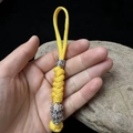 Detail eines gelben Paracord Schlüsselanhängers mit silberner Spartan Perle und Anhänger - Gelb
