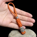 Detail eines handgewebten orangefarbenen Paracord-Schlüsselanhängers mit Totenkopf - Orange