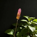 Macro detail of handmade copper wire wrapping on gradient natural crystal flower ornament - Reddish Orange