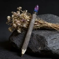 Macro detail of natural wood ballpoint pen with raw purple crystal on black stone - Red & Blue