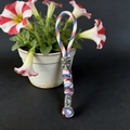 Macro detail of tricolor paracord keychain featuring silver tiki mask and geometric beads - Camo White